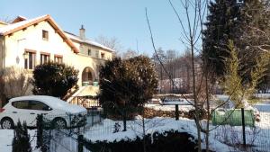 a white car parked in front of a house in the snow at Moulin de la Varenne in Saint-Saturnin