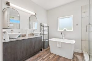 a white bathroom with two sinks and a large mirror at The Ultimate View House in Dallas