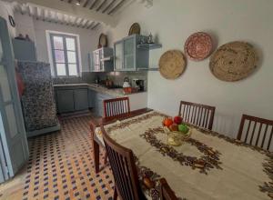 a kitchen with a table with a bowl of fruit on it at Riad darkoum in Essaouira