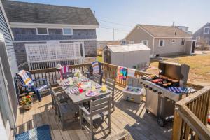 a patio with a table and a grill on a deck at Mimi's Beach House Beach Access in Wells