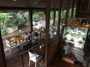 a view of a restaurant with tables and chairs at The ForRest Peace Forest แม่กำปอง in Ban Huai Kaeo