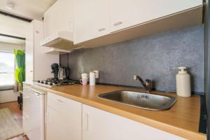 a kitchen with a sink and a stove at Knus houten huisje bij het bos in Anloo