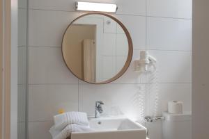 a white bathroom with a mirror and a sink at Hotel Drescher in Mörbisch am See +13 photos