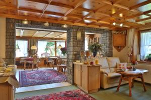 a living room with a fireplace with a couch and a table at Pension Monteneu in Bartholomäberg