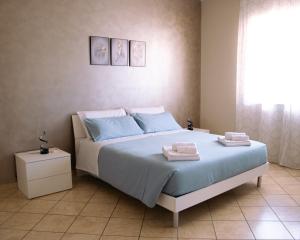 a bedroom with a bed with two towels on it at Tra Onde e Vette in San Leonardello