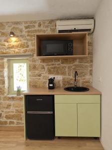 a kitchen with a sink and a microwave at Maison Jolie in Vlachopoulátika +15 photos