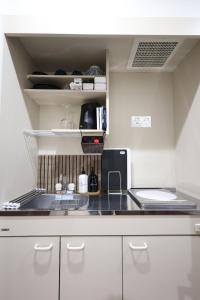 a kitchen with white cabinets and a counter top at たびあかりn in Nishi-nakasange
