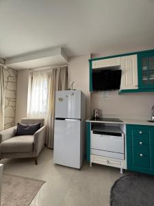 a kitchen with a white refrigerator and a chair at Olea Alacati in Çeşme