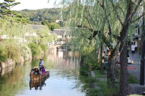 a group of people in a boat on a river at たびあかりn in Nishi-nakasange