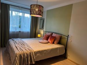 a bedroom with a bed and a chandelier at Jurmala Cozy Vibes - self check in in Jūrmala