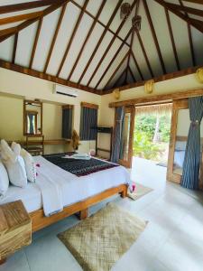 a bedroom with a large bed and a large window at SA Oeona Bungalow in Nembrala +117 photos
