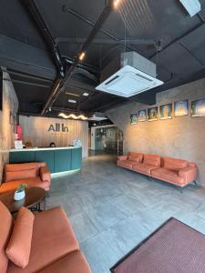 a waiting room with orange couches and a counter at ALL IN HOTEL in Kangar