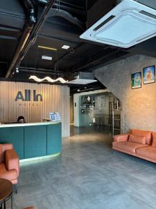 a lobby of an office with couches and a counter at ALL IN HOTEL in Kangar