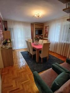 a dining room with a red table and chairs at Rózsa nyaralóház in Balatonboglár