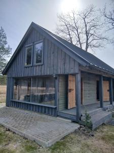 a small wooden house with a large porch at Arakaoja Puhkemaja in Nepste
