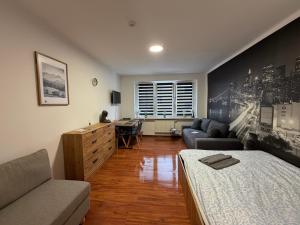 a living room with a bed and a desk in it at ApartmentsByMatyrafa-XVI in Tarnowskie Góry