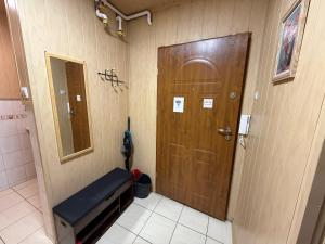 a room with a door and a bench and a mirror at ApartmentsByMatyrafa-XVI in Tarnowskie Góry