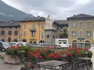 a statue of a woman sitting on top of a fountain at AlipierHome Bernina Gateway Comfort e Spazio vicino al Trenino Rosso in Tirano