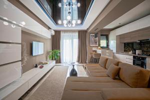 a living room with a couch and a kitchen at Sas 1 Luxury Apartments in Mamaia