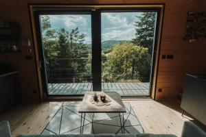 a room with a table in front of a large window at Chalúpka na kopcu in Buchlovice