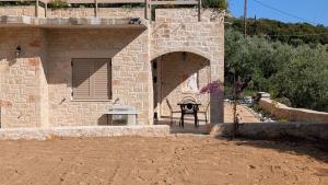 a stone building with a table and an archway at Achilles Cottage in Kardamyli