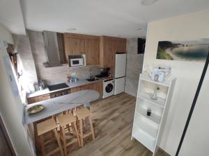 a small kitchen with a table and a refrigerator at Villa Playa del Silencio in Castañeras