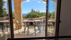 a patio with a table and chairs on a balcony at Achilles Cottage in Kardamyli