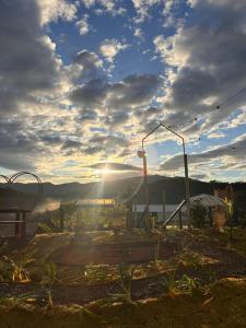 a view of the sun shining through the clouds over a garden at Refugio nas Alturas LANDIN & CHARM in Santo Antônio do Pinhal +128 photos