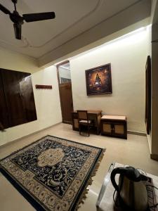 a room with a rug on the floor and a table at Vedic Dham Ganga in Rishīkesh