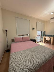a bedroom with a large bed with a pink blanket at Cici Guesthouse in Caminha