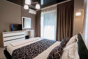 a hotel room with a bed and a television at Sas 1 Luxury Apartments in Mamaia