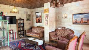 a living room with two couches and a tv at Nature Park Cave Hotel in Göreme