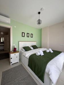 a bedroom with a large bed with green walls at Olea Alacati in Çeşme +32 photos