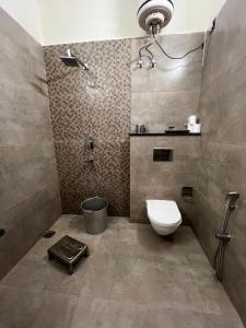 a bathroom with a toilet and a shower at Vedic Dham Ganga in Rishīkesh +79 photos