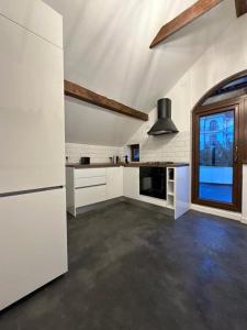 a large white kitchen with a window and a refrigerator at Cismigiu Apartments in Bucharest