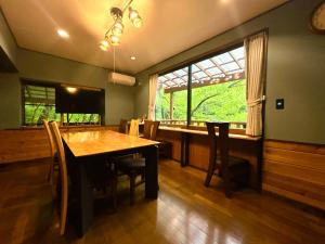 a dining room with a table and a large window at チェックアウトは11時コテージそら豆ん家 in Nasu