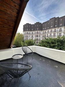 a balcony with two chairs and a table and a building at Cismigiu Apartments in Bucharest