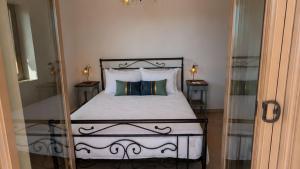 a bedroom with a bed with a mirror next to it at Achilles Cottage in Kardamyli