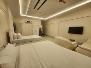 a hotel room with two beds and a flat screen tv at Pc Inn Executive Class Hotel in Sukkur +18 photos