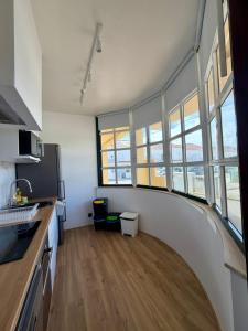 a room with a kitchen and a hallway with windows at Maresia Baleal House in Baleal