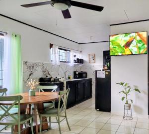a kitchen with a table and chairs and a tv at Casa Emma Quepos in Quepos
