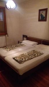 2 camas individuais num quarto com um candeeiro. em Casamanu em Enego
