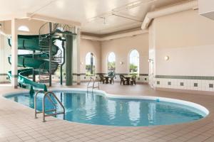 a pool in a hotel with a spiral staircase at Days Inn & Suites by Wyndham Winkler in Winkler