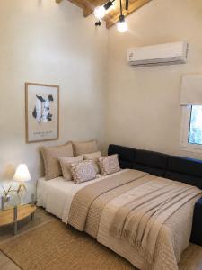 a bedroom with a large bed with a black couch at Casa Ortensia in Kato Korakiana