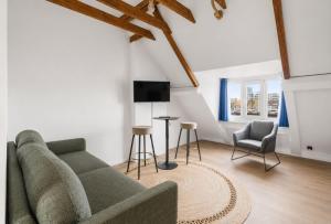 a living room with a couch and a tv at Oyster Loft Ostend in Ostend