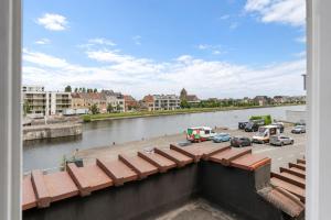 a view of a river with cars parked in a parking lot at Oyster Loft Ostend in Ostend