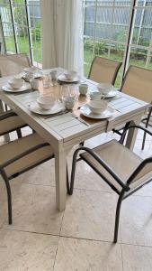 a white table with bowls and plates on it at Villa Nueva Martinique in Gros-Morne