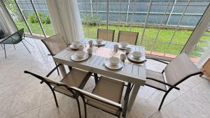 a dining room table with chairs and a table and chairsktop at Villa Nueva Martinique in Gros-Morne