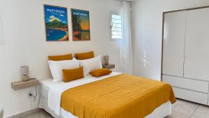a bedroom with a large bed with a yellow blanket at Villa Nueva Martinique in Gros-Morne +9 photos