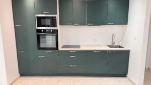 a kitchen with green cabinets and a sink at Villa Nueva Martinique in Gros-Morne